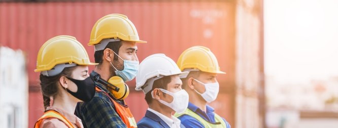 construction workers wearing hard hats and masks 